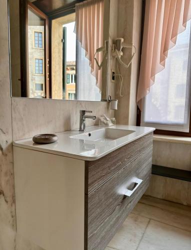 a bathroom with a sink and a mirror at Relais Ponte Pietra in Verona
