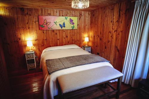 a bedroom with two beds in a wooden room at Vista al volcán con tinaja y río en Conguillío in Curacautín