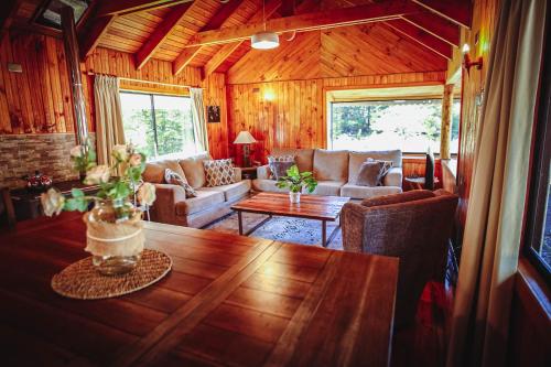 a living room with a couch and a table at Vista al volcán con tinaja y río en Conguillío in Curacautín