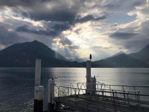 a dock on a body of water with a person on it at Emma House in Bellano