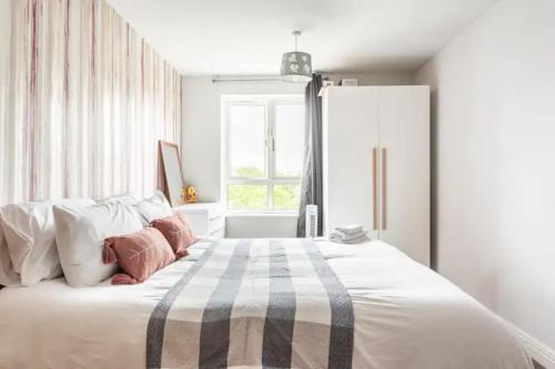 倫敦的住宿－Lovely en-suite double room，白色的卧室设有一张大床和一个窗户