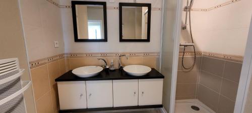 une salle de bain avec deux lavabos et une douche dans l'établissement Le Lido, à Saint-Jean-de-Monts