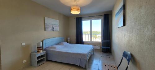 une petite chambre avec un lit et une fenêtre dans l'établissement Le Lido, à Saint-Jean-de-Monts