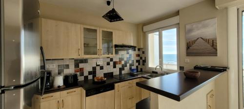 une cuisine avec un évier et un plan de travail dans l'établissement Le Lido, à Saint-Jean-de-Monts