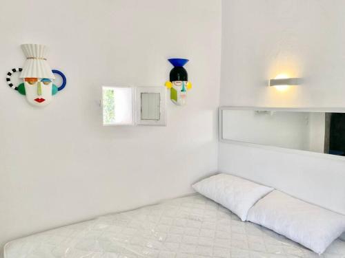a white room with a bed and a mirror at Cabarnus House in Parikia