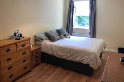 a bedroom with a bed with a teddy bear on it at Beaumont Court in Coventry