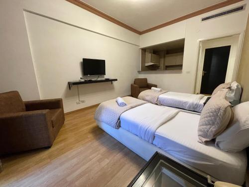 ベイルートにあるElegant Suites Beirutのベッド2台と薄型テレビ付きのホテルの部屋