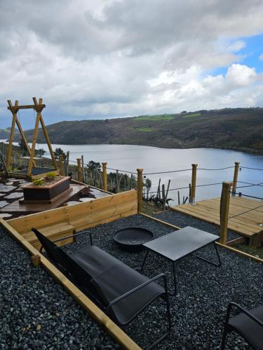 a patio with a table and chairs and a lake at Viña Candaz By Oktheway in Taboada