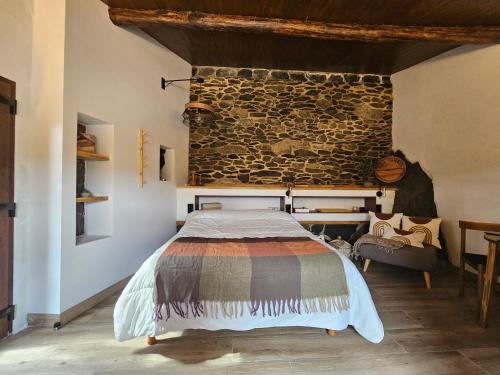 a bedroom with a bed and a stone wall at Viña Candaz By Oktheway in Taboada