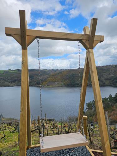 a wooden swing with a lake in the background at Viña Candaz By Oktheway in Taboada