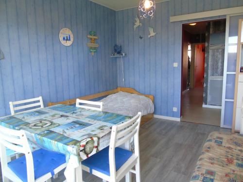 une salle à manger avec une table et un lit dans l'établissement Les Vignes, à Saint-Jean-de-Monts