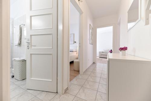 a white door in a white room with a bathroom at Near old town apartment with free parking and air condition in each room in Zadar