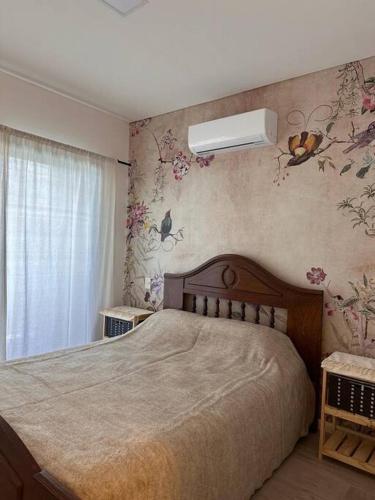 a bedroom with a bed with flowers on the wall at Departamento Amoblado de lujo! in Pilar