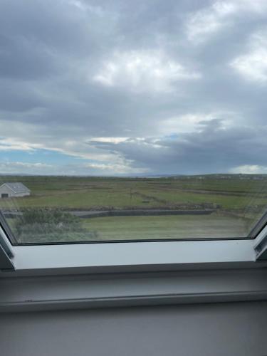 a window in a room with a view of a field at Cois na mara bridges of Ross V15 T677 in Kilbaha