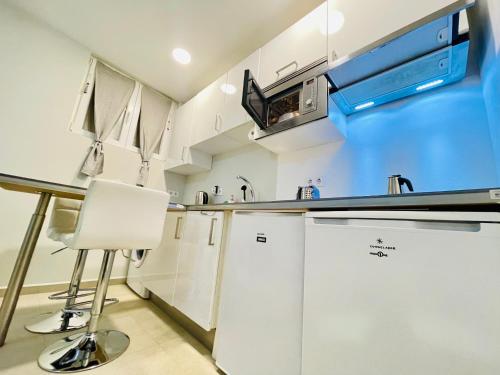 eine Küche mit weißen Schränken und einer Arbeitsplatte in der Unterkunft MADRID CENTRO in Madrid