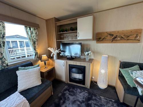 a small living room with a bed and a television at A Beautiful Dog Friendly Holiday Home in Mablethorpe