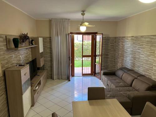 un salon avec un canapé et une table dans l'établissement Relax Sea Capomulini Appartamento su due livelli, à Acireale