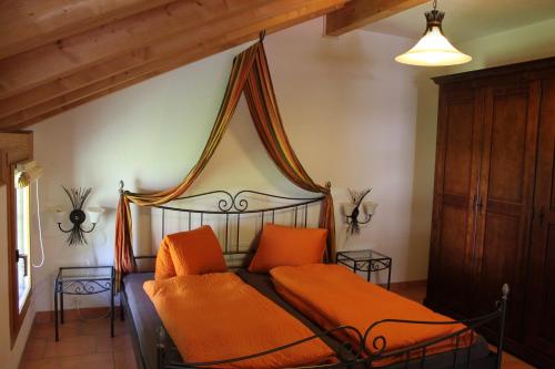 ein Schlafzimmer mit einem Bett mit orangefarbenen Kissen in der Unterkunft Pension St. Jakob in Engelberg