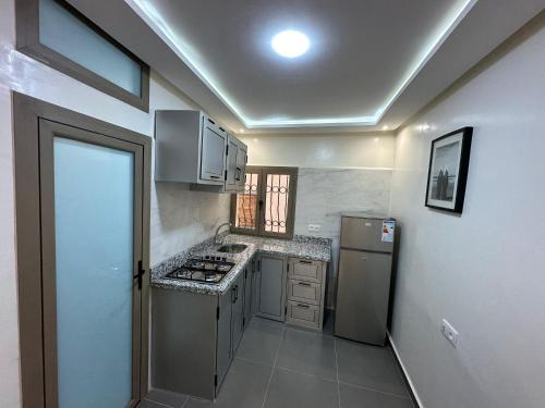 uma pequena cozinha com um fogão e um frigorífico em Taghazout appartement em Taghazout