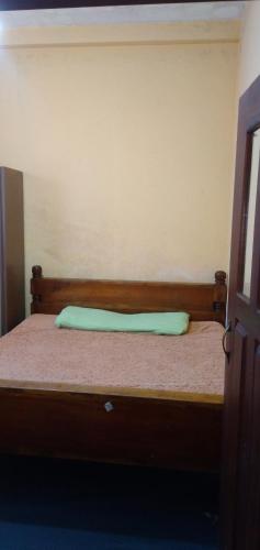 Una cama con una almohada verde encima. en Hill view villa, en Nuwara Eliya