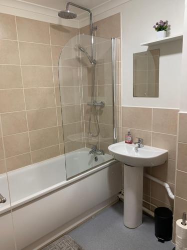 a bathroom with a shower and a sink and a tub at 1 Bedroom Flat Apartment Bromley in Bromley