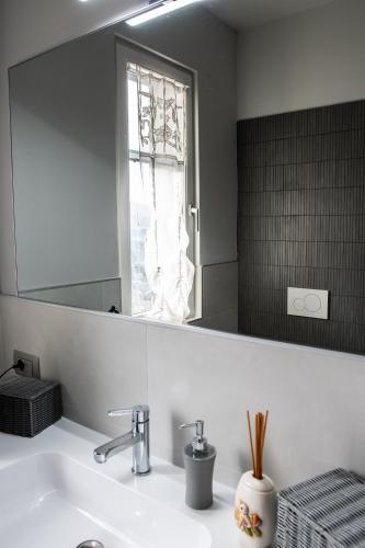 a bathroom sink with a mirror and a window at Monte Moro Gavi B&B in Gavi