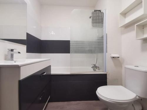 La salle de bains blanche est pourvue de toilettes et d'un lavabo. dans l'établissement Le Nid Canal Piscine Résidence, à Béziers