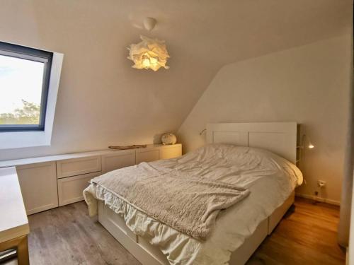 une chambre avec un lit blanc et une fenêtre dans l'établissement Carnac: Duplex T3 4 pers, à 200m plage, WIFI, Parking - FR-1-377-71, à Carnac
