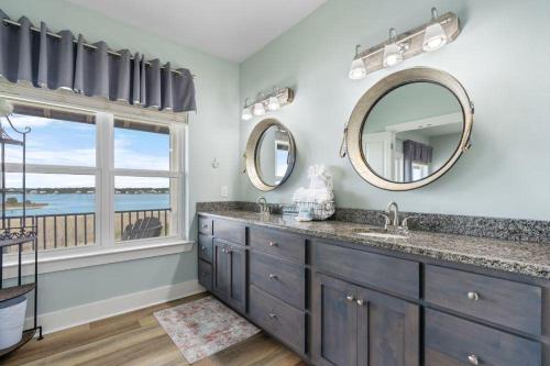 ein Badezimmer mit zwei Waschbecken und zwei Spiegeln in der Unterkunft Linger4Longer - Pass Time 4 in Gulf Shores