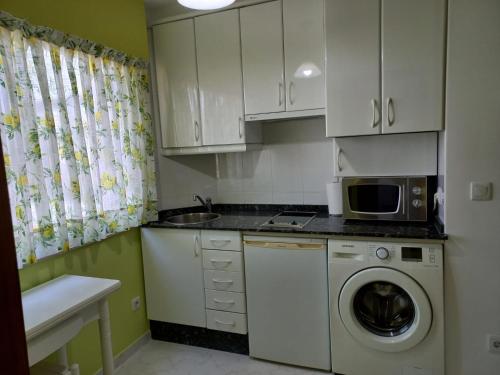 a kitchen with a washing machine and a microwave at Apartamento Landra VUT-CO-003165 in Padrón