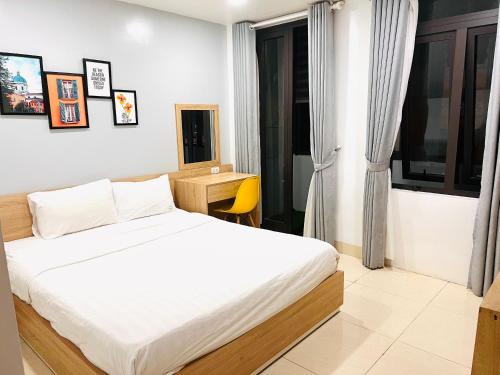 a bedroom with a bed and a desk in it at Luna House Danang in Danang