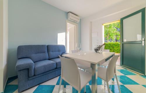 a living room with a blue couch and a table and chairs at Beautiful Apartment In Deiva Marina in Deiva Marina