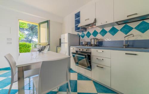 a kitchen with white cabinets and a counter with a table at Beautiful Apartment In Deiva Marina in Deiva Marina