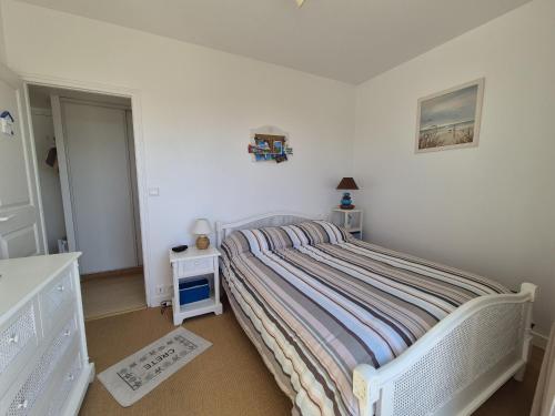 - une chambre blanche avec un lit et une table de nuit dans l'établissement L'Hollywood, à Saint-Jean-de-Monts