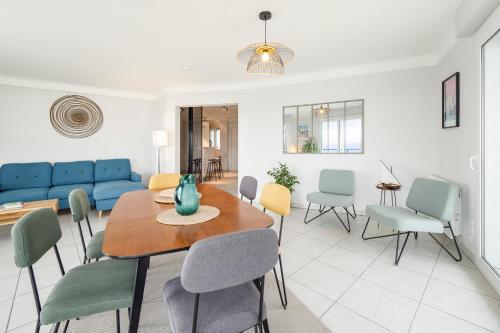 une salle à manger et un salon avec une table et des chaises dans l'établissement HEOL, 5ème étage,Face mer, à La Baule