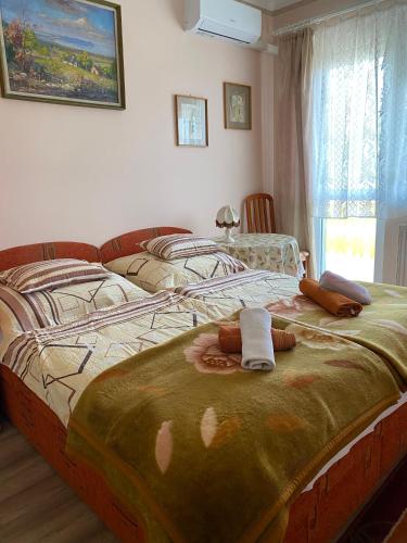 a bedroom with two beds with towels on the bed at Károly Vendégház in Hévíz