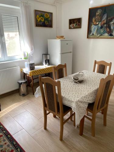a kitchen with a table and chairs and a refrigerator at Károly Vendégház in Hévíz