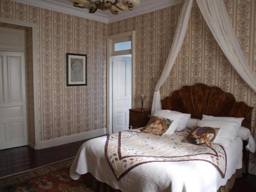 a bedroom with a canopy bed with a dog laying on it at Villa Magnolia Parc - adults only in Montélimar