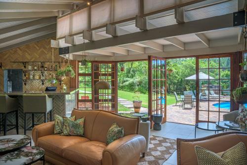 an open living room with a couch and a bar at The Fernery Lodge & Spa in Stormsrivier