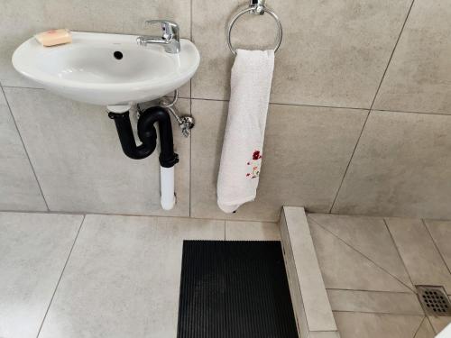 a bathroom with a sink and a white towel at Sem's Guest Cottage in Edenvale