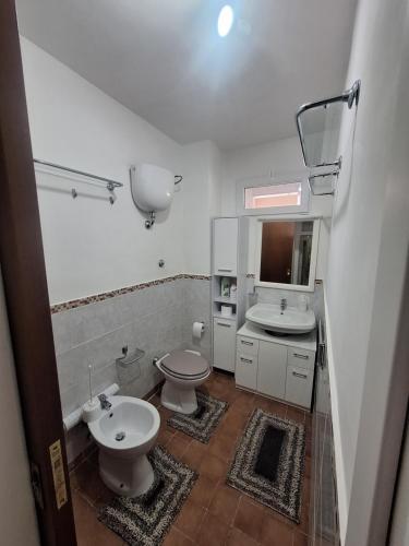 La salle de bains est pourvue de 2 toilettes, d'un lavabo et d'un miroir. dans l'établissement Casa Vacanze MAMI home 2/5 pers., à San Cesareo