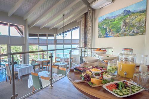 a table with a plate of food on top of it at The Fernery Lodge & Spa in Stormsrivier