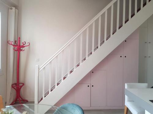 un escalier avec des armoires blanches et une table en verre dans l'établissement Le DUPLEX de Boulogne/Roland Garros/1 à 4 personnes, à Boulogne-Billancourt