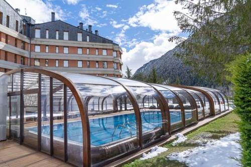 a building with a swimming pool next to a building at Hotel Montarto in Baqueira-Beret
