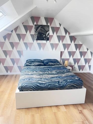 - une chambre dotée d'un lit avec un mur géométrique dans l'établissement Le calme et l'air marin, à Gonneville-en-Auge