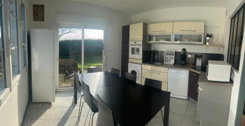 une cuisine avec une table et un comptoir noir dans l'établissement Le calme et l'air marin, à Gonneville-en-Auge