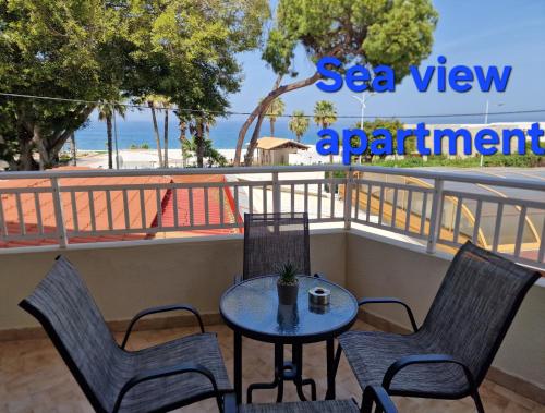 a table and chairs on a balcony with a view of the beach at BLUE EYES APARTMENTS in Ixia