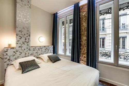 - une chambre avec un lit blanc et 2 fenêtres dans l'établissement Les Jacobins, hypercentre, à Lyon