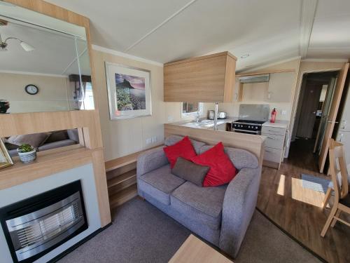 a living room with a couch and a fireplace at Stunning modern lodge in Port Seton