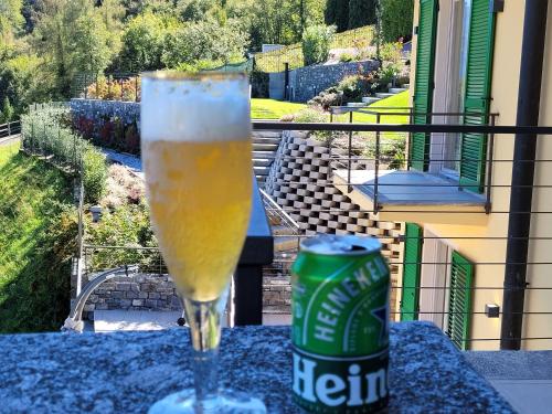 a glass of beer sitting on a table with a can of beer at PARADISE VILLA VISTA LAGO DI COMO A MENAGGIO in Menaggio